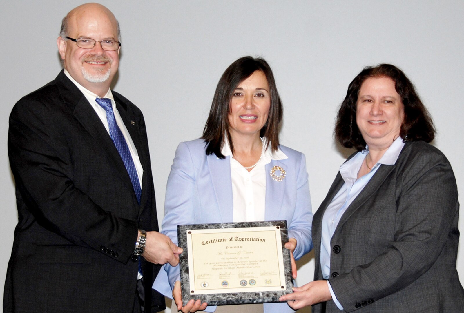 Philip Hepperle (left), director of equal employment opportunity for the Defense Contract Audit Agency, and DCAA Director Anita Bales (right) present a certificate of appreciation to Carmen Cantor (center), director of Ccivil Sservice human resource management for the U.S. State Department.