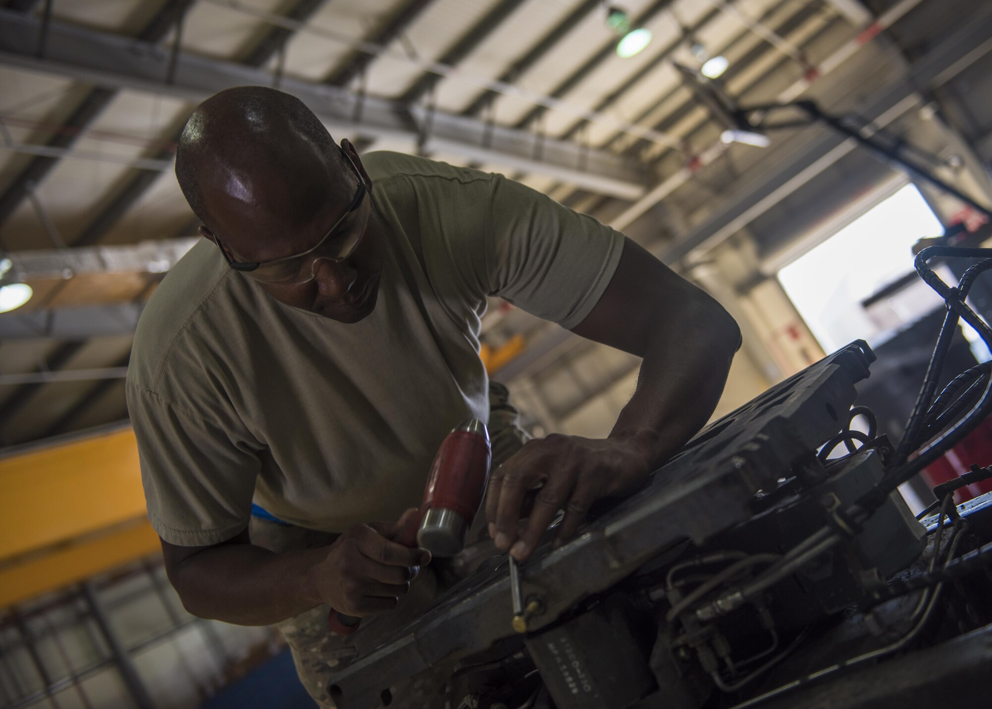 Tech. Sgt. Matthew Heeter, 455th Expeditionary Maintenance Squadron aerospace ground equipment floor lead, uses a hammer to tap a punch while replacing a tilt cycle on a munitions lift, Bagram Airfield, Afghanistan, Sept. 22, 2016. AGE mechanics maintain and repair equipment that supply electricity, hydraulic pressure and air pressure to aircraft. They play an essential role in making sure aircraft are ready for flight. (U.S. Air Force photo by Senior Airman Justyn M. Freeman)