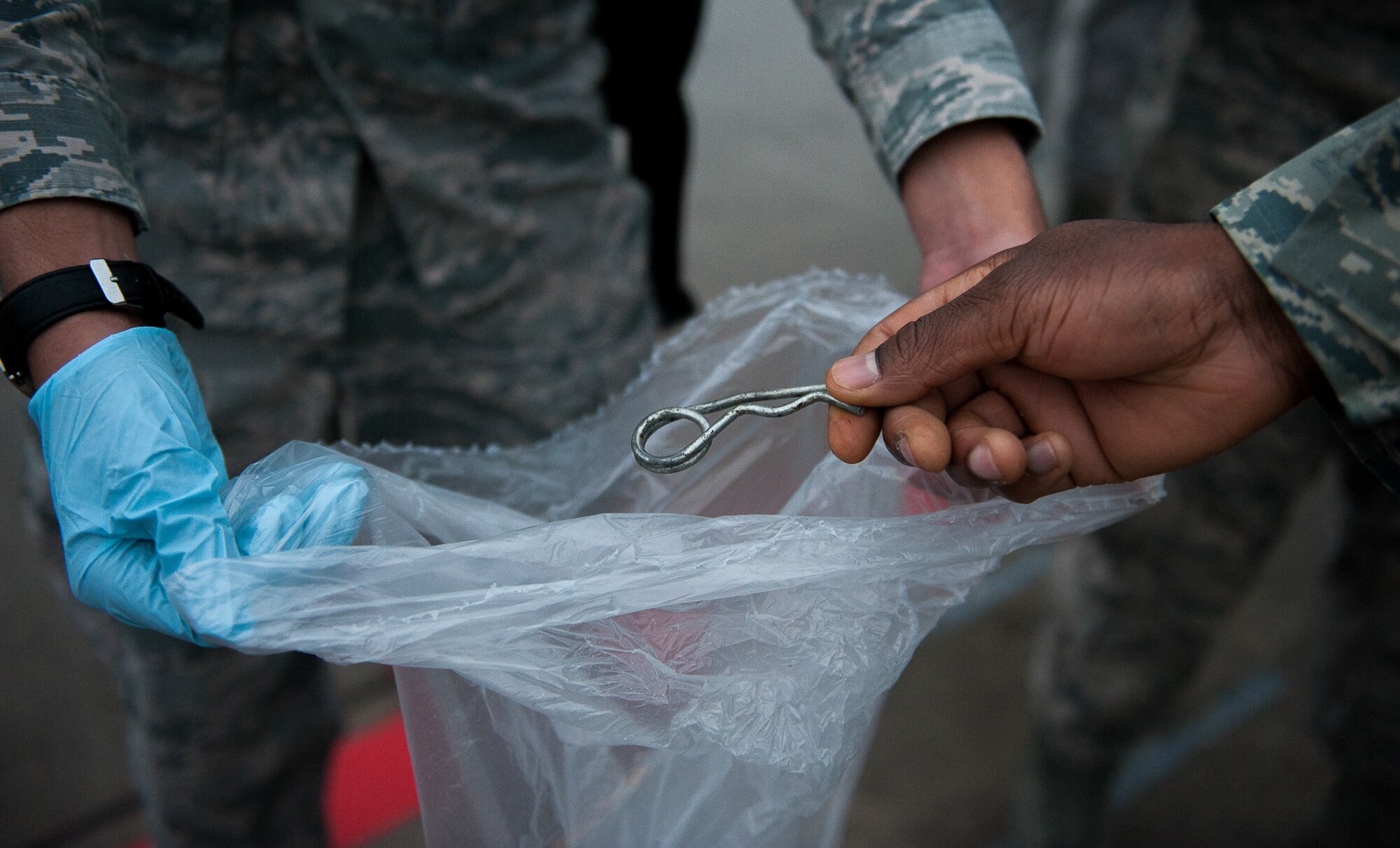 An Airman drops a piece of metal into a trash bag during a foreign object damage prevention walk Sept. 20, 2016, at Ramstein Air Base, Germany. The Ramstein Bazaar was held this past weekend, and over 300 Airmen came to participate in a FOD walk after the event to pick up any remaining debris left behind. (U.S. Air Force photo/ Airman 1st Class Savannah L. Waters)