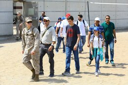 A U.S. Marine with the 22nd Marine Expeditionary Unit escorts U.S. and international citizens  during a bilateral non-combatant evacuation exercise at the U.S. Embassy, Muscat, Oman, Sept. 21, 2016. The non-combatant evacuation exercise is an opportunity for the United States and Oman to practice a bilateral mission of quickly providing security and safety to U.S. and international citizens abroad during a natural disaster or contingency.