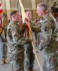 Lt. Col. Peter F. Gleason, a Tracy, California resident and 63rd Brigade Support Battalion incoming commander, is passed the unit guidon from Col. Joseph Riciardi, 303rd Maneuver Enhancement Brigade commander, and assumed command of the 63rd BSB from Lt. Col. Debra A. Cisney, who has led the unit for the past two years, at the George W. Dunaway Army Reserve Center in Sloan, Nev. September 10.