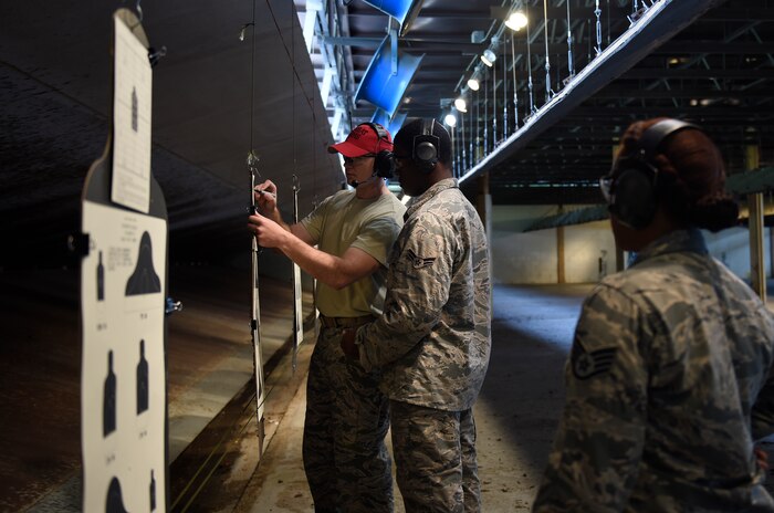 Staff Sgt. Alexander Elder, 628th Security Forces Squadron combat arms training and maintenance instructor calculates the firing score for Airman 1st Class Courtland Carson, 628th Logistics Readiness Squadron fuels distribution technician here, Sept. 13, 2016. Airmen fired the M4 rifle as part of a weapons qualification in preparation for a deployment, permanent change of station move or as part of annual training. 