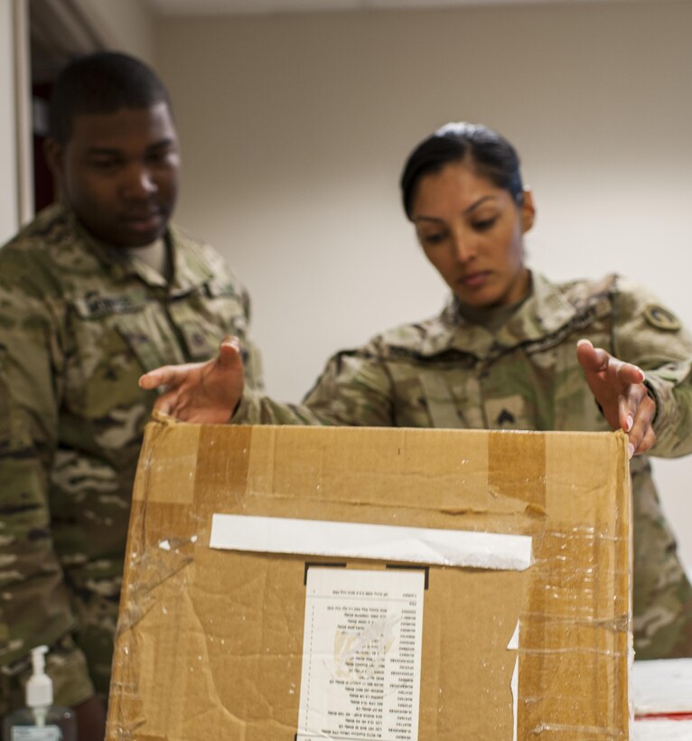 Pfc. Jamaal Monroe, and Sgt. Jennifer Schwausch, mail specialists with the 14th Human Resources Sustainment Center, Fort Bragg, N.C., examine a simulated package during a Mission Readiness Exercise, Sept. 21, 2016. The 14th Human Resources Sustainment Center will be deploying to the U.S. Army Central Command theater. (U.S. Army photo by Timothy L. Hale)(Released)