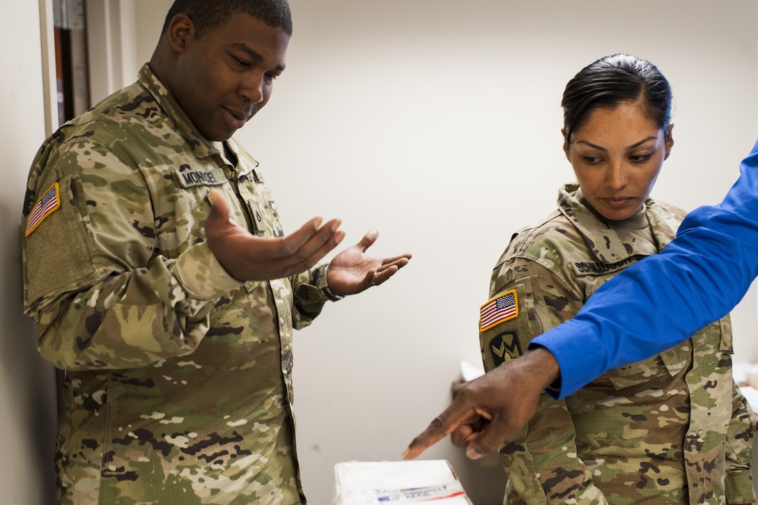 Pfc. Jamaal Monroe and Sgt. Jennifer Schwausch, mail specialists with the 14th Human Resources Sustainment Center, Fort Bragg, N.C., look at a simulated suspicious package during a Mission Readiness Exercise, Sept. 21, 2016. The 14th Human Resources Sustainment Center will be deploying to the U.S. Army Central Command theater. (U.S. Army photo by Timothy L. Hale)(Released)