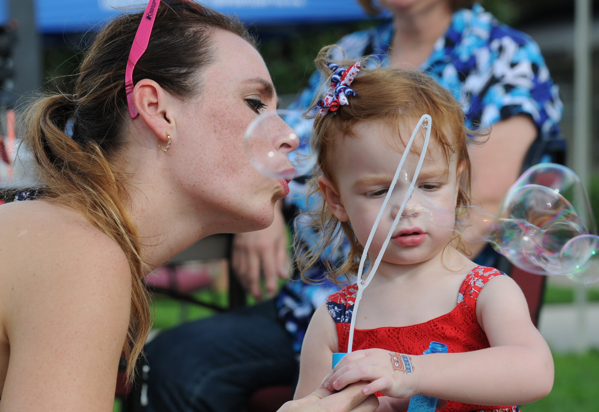 Capt. (Dr.) Lynsey Cox, 81st Surgical Operations Squadron OBGYN, blows bubbles with her daughter, Lucy, during Keesler’s Air Force birthday celebration in front of Vandenberg Hall Sept. 16, 2016, on Keesler Air Force Base, Miss. The event included a cake-cutting ceremony, music and food to celebrate the Air Force’s 69th birthday. (U.S. Air Force photo by Kemberly Groue/Released)
