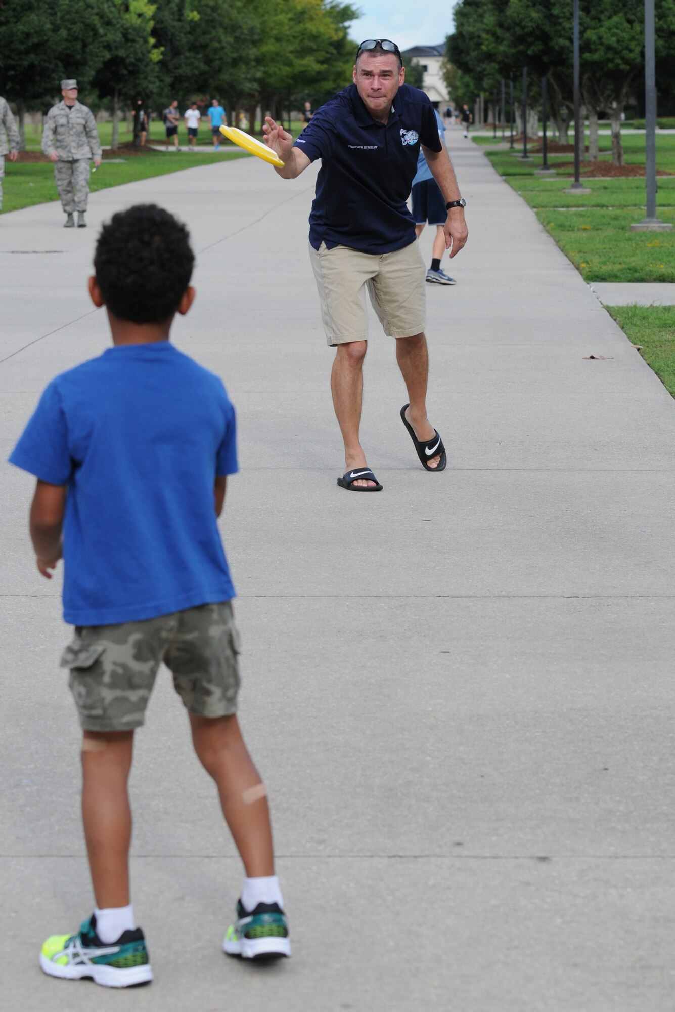 Chief Master Sgt. Leonard Trombley Jr., 81st Training Support Squadron qualification training flight chief, throws a Frisbee to his son, Josiah, during Keesler’s Air Force birthday celebration in front of Vandenberg Hall Sept. 16, 2016, on Keesler Air Force Base, Miss. The event included a cake-cutting ceremony, music and food to celebrate the Air Force’s 69th birthday. (U.S. Air Force photo by Kemberly Groue/Released)