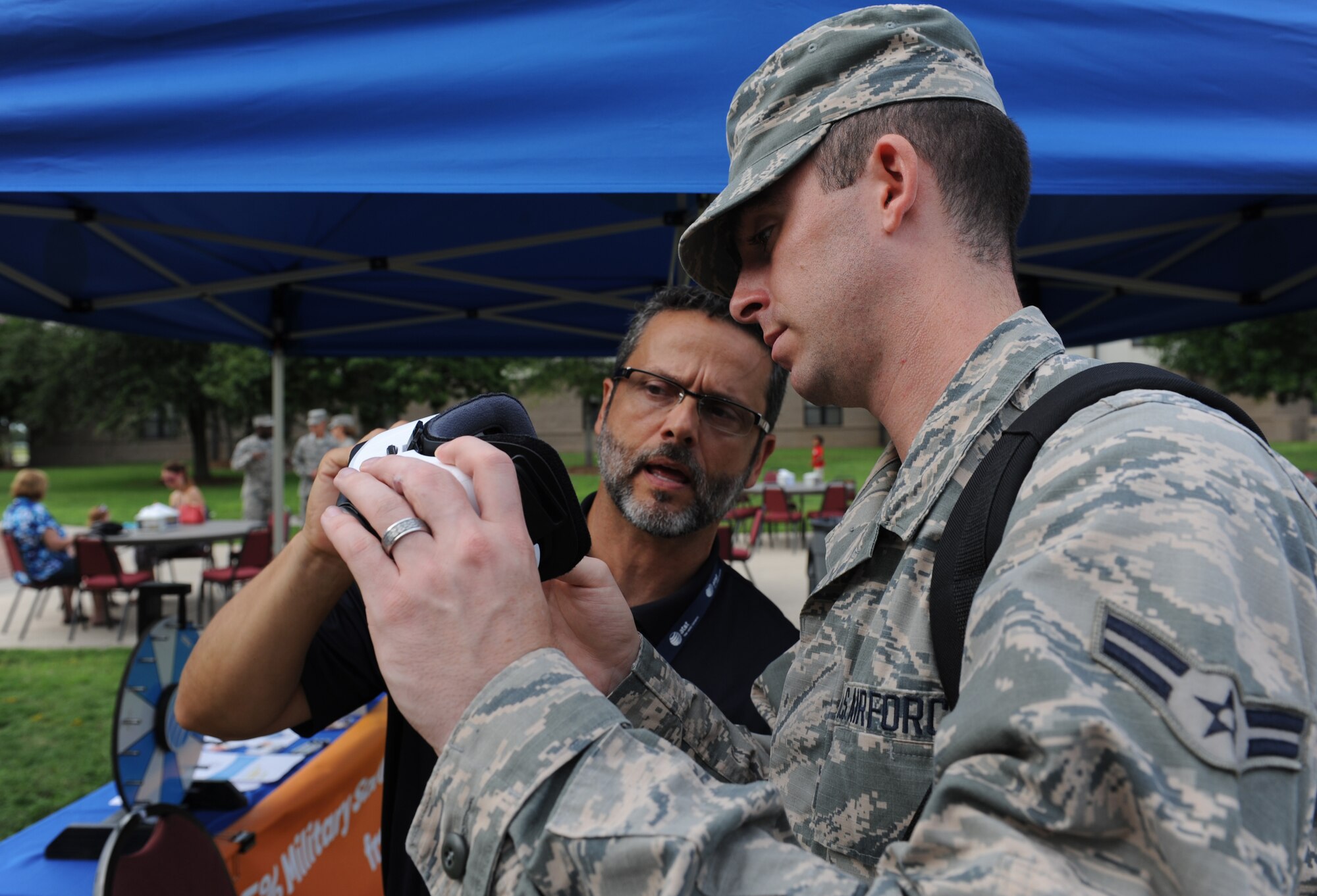 Tom Viator, AT&T military marketing associate, shows virtual reality goggles to Airman 1st Class Travis Beihl, 81st Training Wing Public Affairs photojournalist, during Keesler’s Air Force birthday celebration in front of Vandenberg Hall Sept. 16, 2016, on Keesler Air Force Base, Miss. The event included a cake-cutting ceremony, music and food to celebrate the Air Force’s 69th birthday. (U.S. Air Force photo by Kemberly Groue/Released)