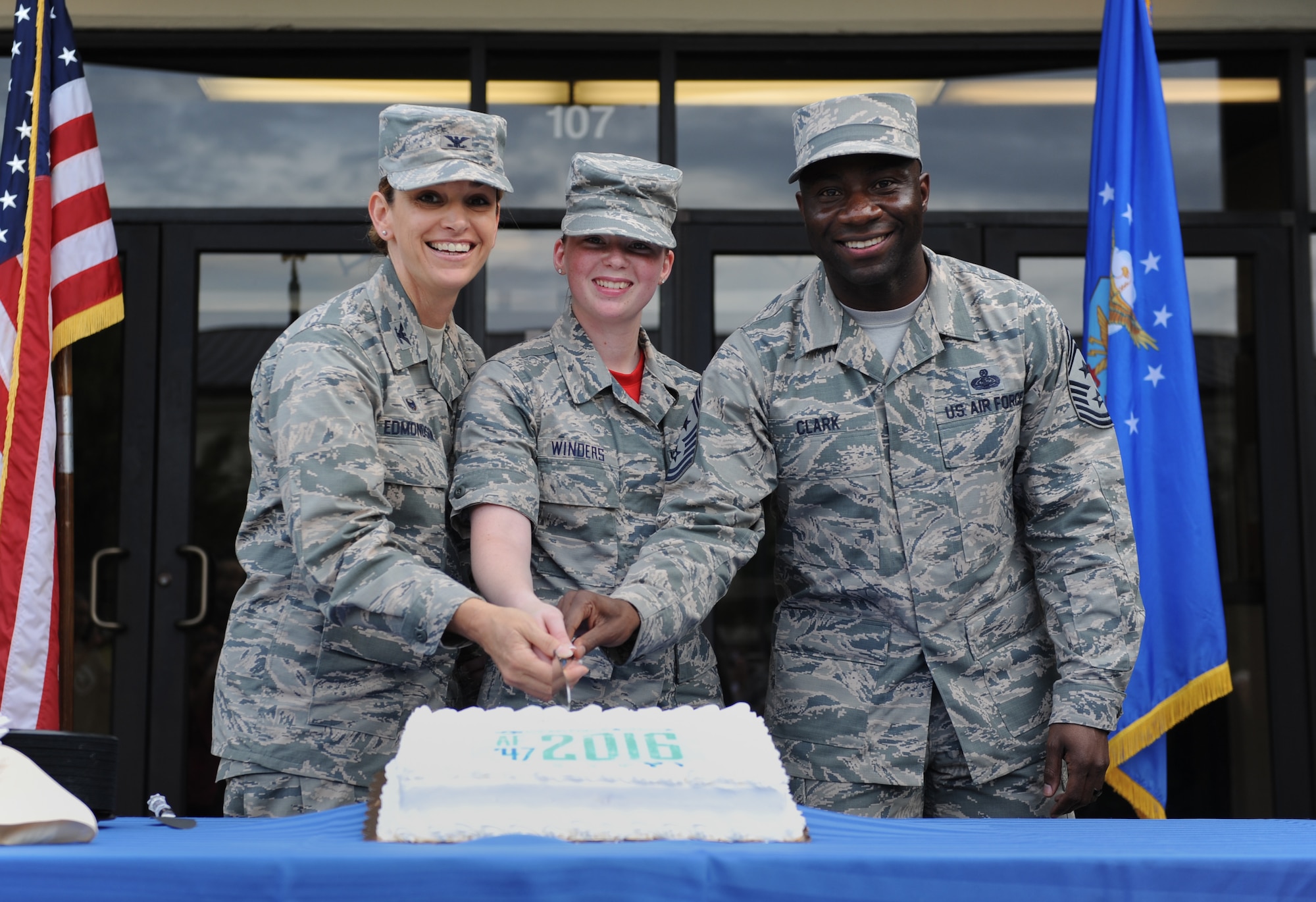 Col. Michele Edmondson, 81st Training Wing commander; Airman Basic Willow Winders, 336th Training Squadron student and the youngest Airman at Keesler, and Chief Master Sgt. Vegas Clark, 81st TRW command chief, pose for a photo while cutting the cake during Keesler’s Air Force birthday celebration in front of Vandenberg Hall Sept. 16, 2016, on Keesler Air Force Base, Miss. The event included a cake-cutting ceremony, music and food to celebrate the Air Force’s 69th birthday. The cake cutting ceremony is an Air Force tradition done performed by wing leadership and the youngest Airman on base. (U.S. Air Force photo by Kemberly Groue/Released)