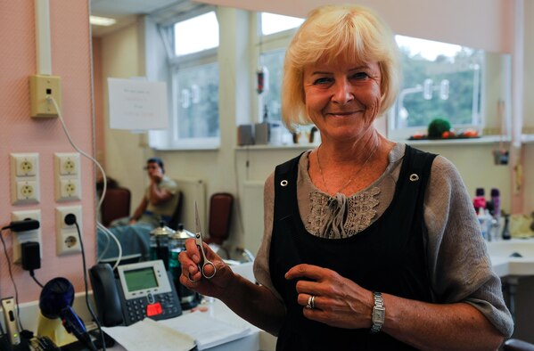 Claudia Gomez, barber, poses for a portrait in her barber shop Sept. 20, 2016, at Ramstein Air Base, Germany. She has been cutting hair at Ramstein Air Base, Germany, since 1981. She is a quiet worker who enjoys working “in the background” and welcoming Airmen and their families to a relaxed environment where they can decompress. (U.S. Air Force photo/Airman 1st Class Lane T. Plummer)