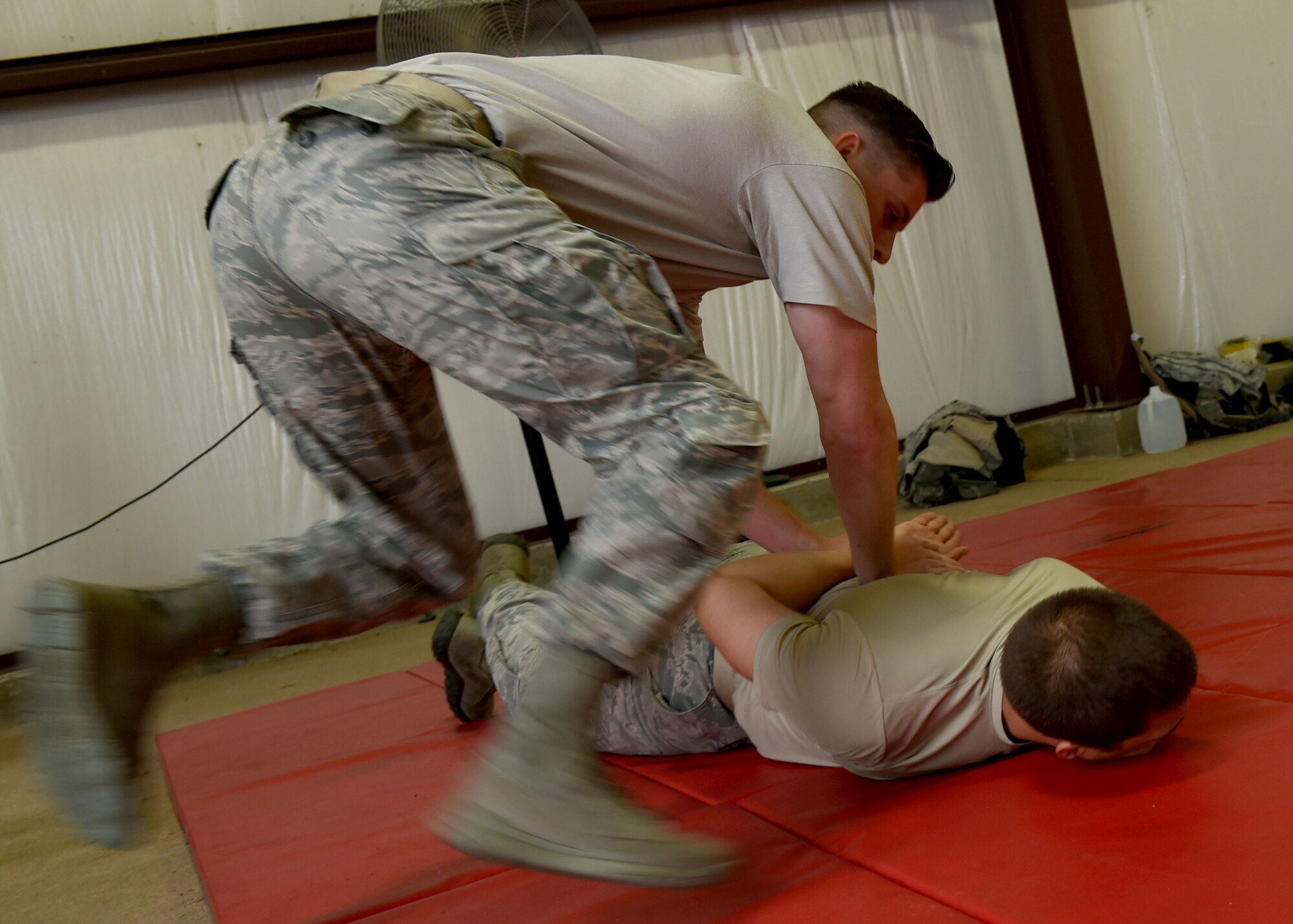 Members of the 97th Security Forces Squadron practice take down maneuvers on Sept. 13, 2016, Altus Air Force Base, Okla. 97th SFS Airmen participated in a week-long training course that taught hand-to-hand defensive and subduing techniques, weapons handling and clearing and securing buildings, aircraft and buses as a team. (U.S. Air Force photo by Airman 1st Class Kirby Turbak/Released)   