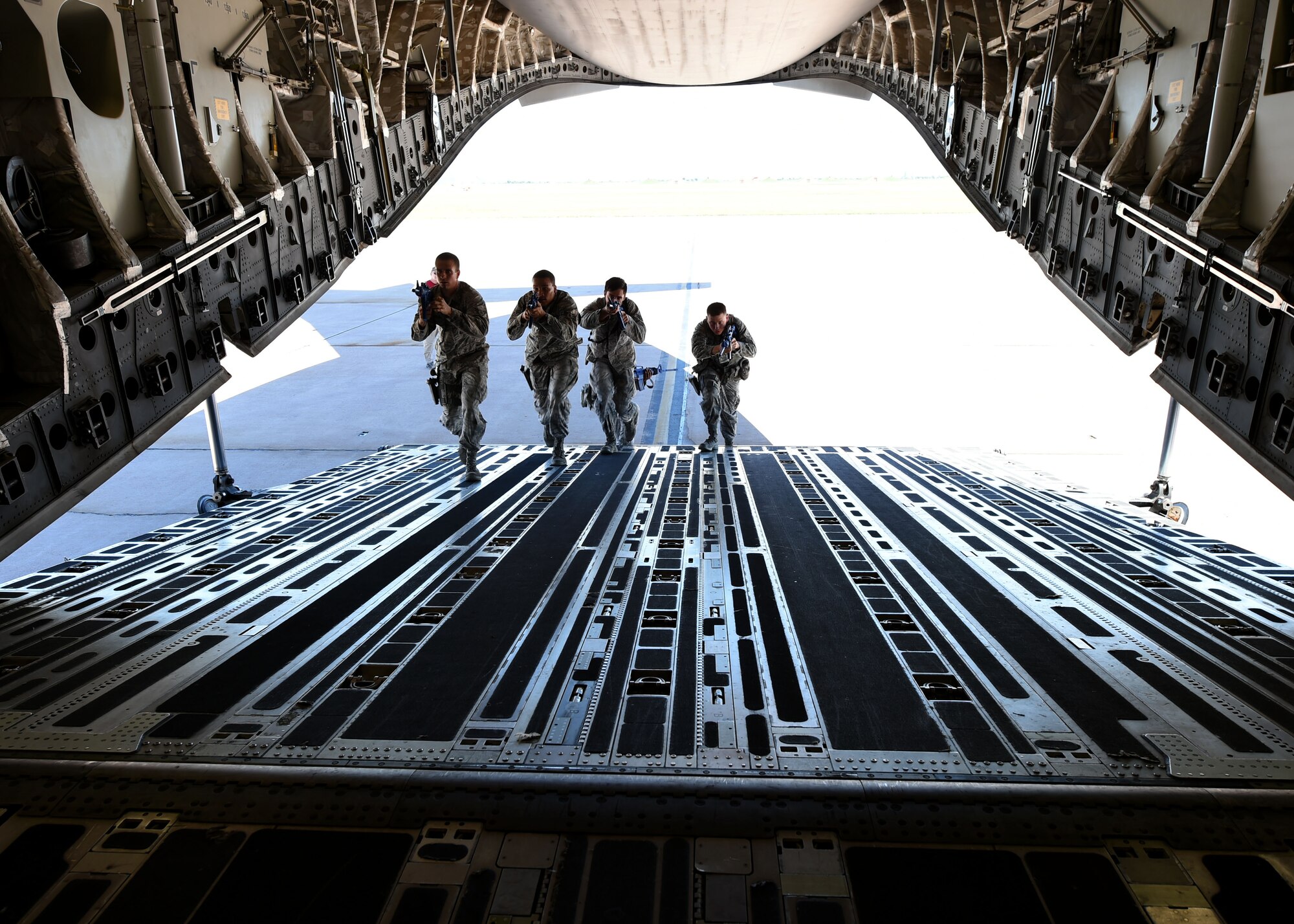 Members of the 97th Security Forces Squadron practice clearing a U.S. Air Force C-17 Globemaster III cargo aircraft during training on Sept. 16, 2016, Altus Air Force Base, Okla. 97th SFS Airmen participated in a week-long training course that taught hand-to-hand defensive and subduing techniques, weapons handling and clearing and securing buildings, aircraft and buses as a team. (U.S. Air Force photo by Airman 1st Class Kirby Turbak/Released)   