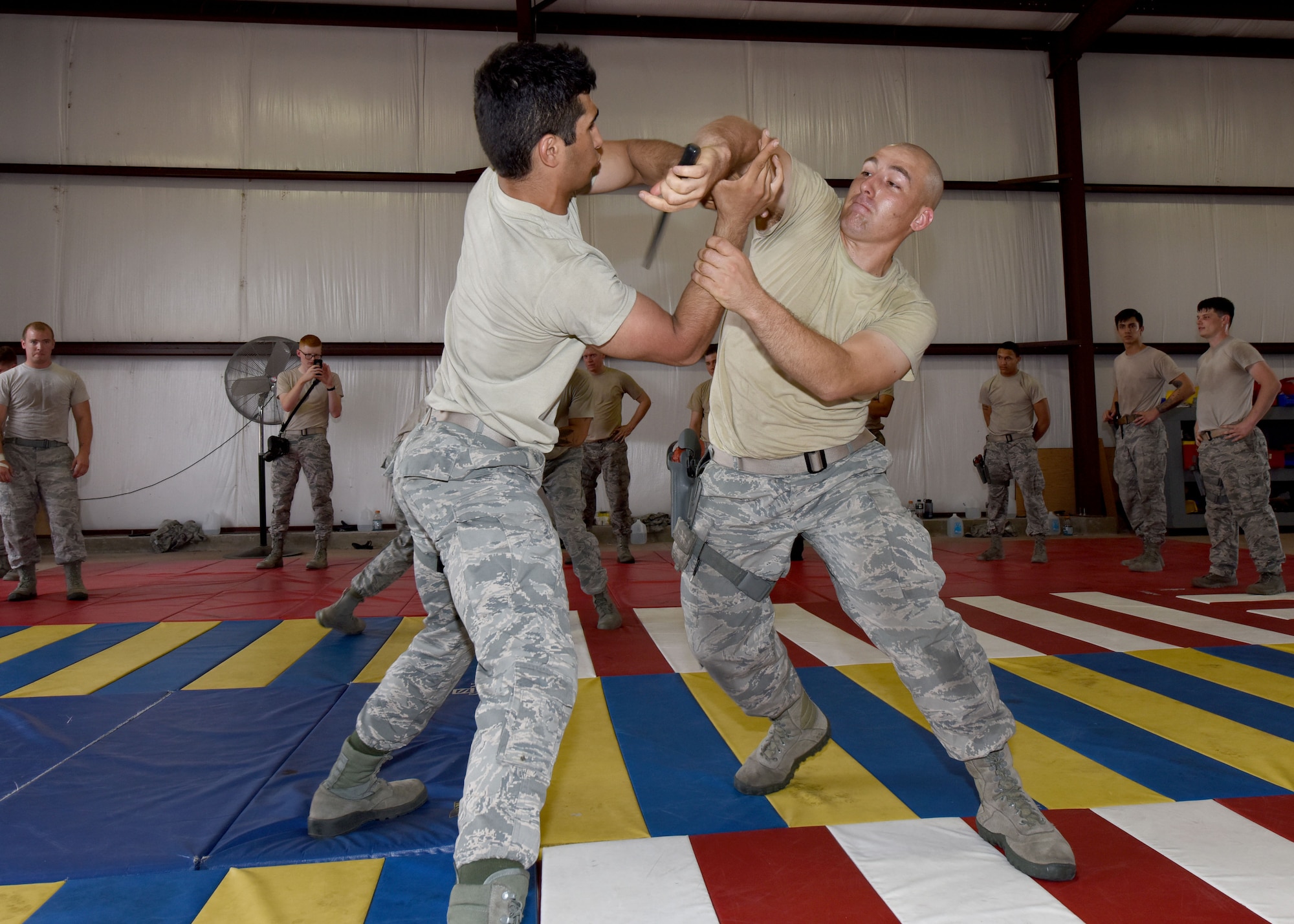 U.S. Air Force Airmen 1st Class Raumeen Hosseini and John Noble, 97th Security Forces Squadron response force members, practice defensive drills against a knife attack at Altus Air Force Base, Okla., Sept. 15, 2016. 97th SFS Airmen participated in a week-long training course that taught hand-to-hand defensive and subduing techniques, weapons handling and clearing and securing buildings, aircraft and buses as a team. (U.S. Air Force photo by Senior Airman Nathan Clark/Released)