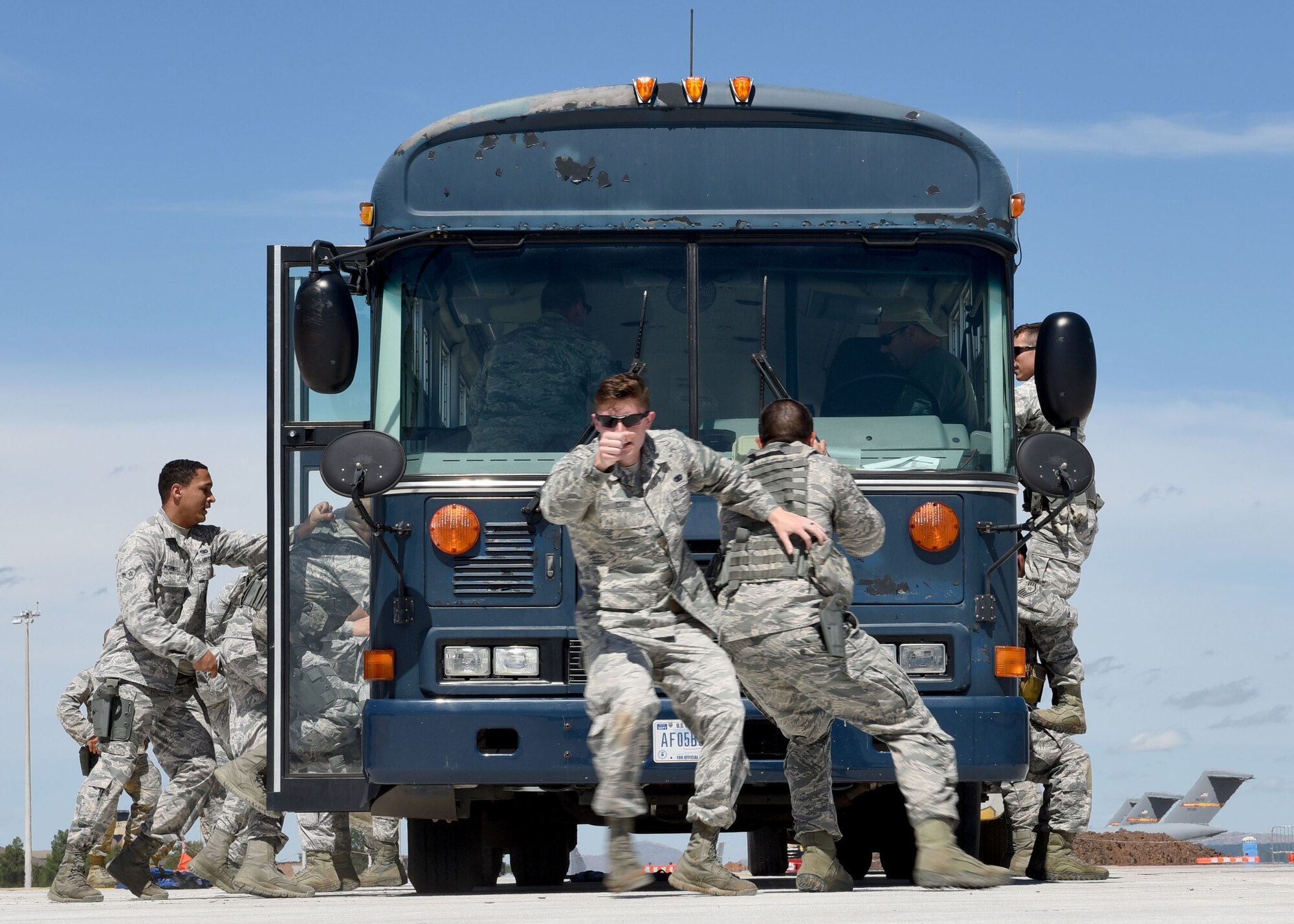 97th Security Forces Squadron members practice securing a bus at Altus Air Force Base, Okla., Sept. 16, 2016. 97th SFS Airmen participated in a week-long training course that taught hand-to-hand defensive and subduing techniques, weapons handling and clearing and securing buildings, aircraft and buses as a team. (U.S. Air Force photo by Senior Airman Nathan Clark/Released)