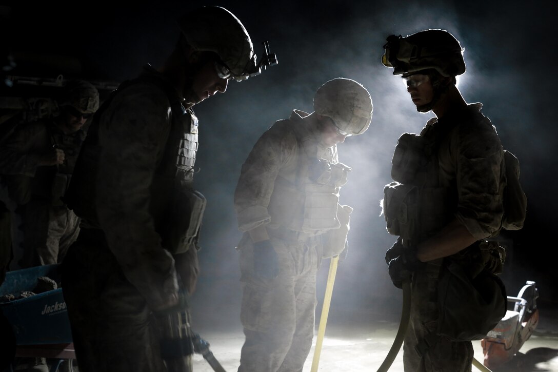 U.S. Marine Corps Lance Cpl. Trinity Brown, right, a combat engineer with Marine Wing Support Squadron 373, Special Purpose Marine Air-Ground Task Force - Crisis Response - Central Command, holds a jack hammer air hose while conducting airfield damage repairs at Al Taqaddum Air Base, Iraq, Aug. 19, 2016. U.S. Marines and Sailors assigned to Special Purpose Marine Air-Ground Task Force-Crisis Response-Central Command support operations, contingencies and security cooperation in Marine Corps Forces Central Command and U.S. Central Command area of responsibility. (U.S. Marine Corps photo by Cpl. Trever Statz)