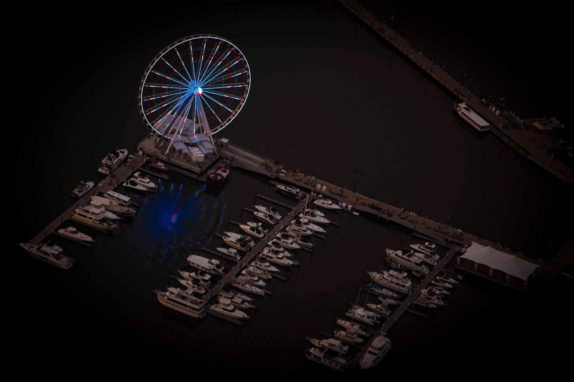 The sun sets on the National Harbor, Oxon Hill, Md., during a "Warbirds" flight Sept. 21, 2016. The flight was part of the dress rehearsal for the 2016 Air Force Tattoo scheduled to be held at Joint Base Anacostia-Bolling, Washington, D.C., Sept. 22. The formation includeds a B-25 Mitchell and a P-51 Mustang. (U.S. Air Force photo by Airman 1st Class Rustie Kramer) 