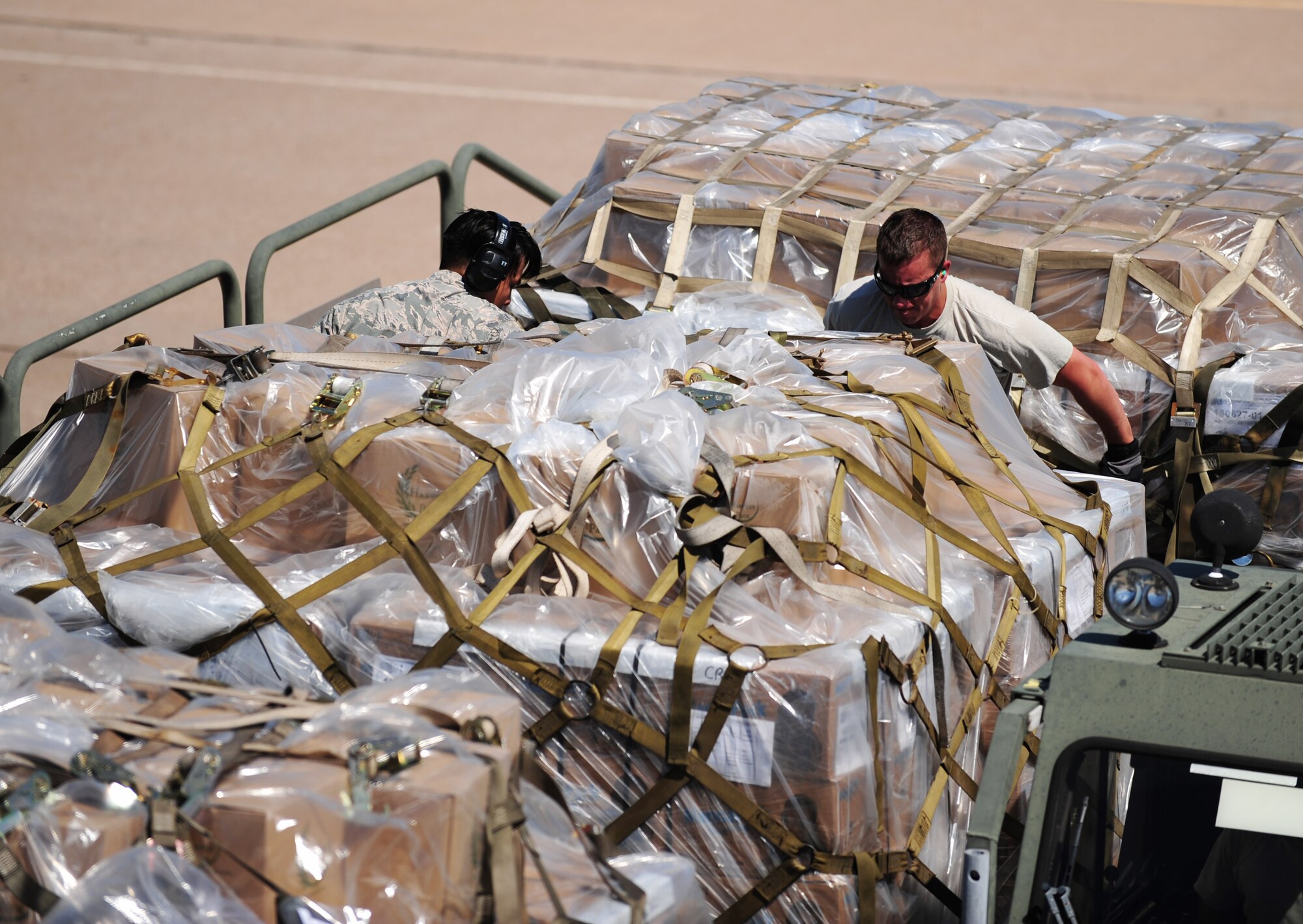 U.S. Air Force Senior Airman Brian Ho, left, and Staff Sgt. Eric Hazelwood, 7th Logistics Readiness Squadron air transportation specialists, push Global Samaritan Resources’ pallets of food onto a vehicle at Dyess Air Force Base, Texas, Sept. 20, 2016. When the shipment arrives at its location, the Barzani Charity Foundation will pick it up and distribute it to Iraqi refugees. (U.S. Air Force photo by Airman 1st Class April Lancto)