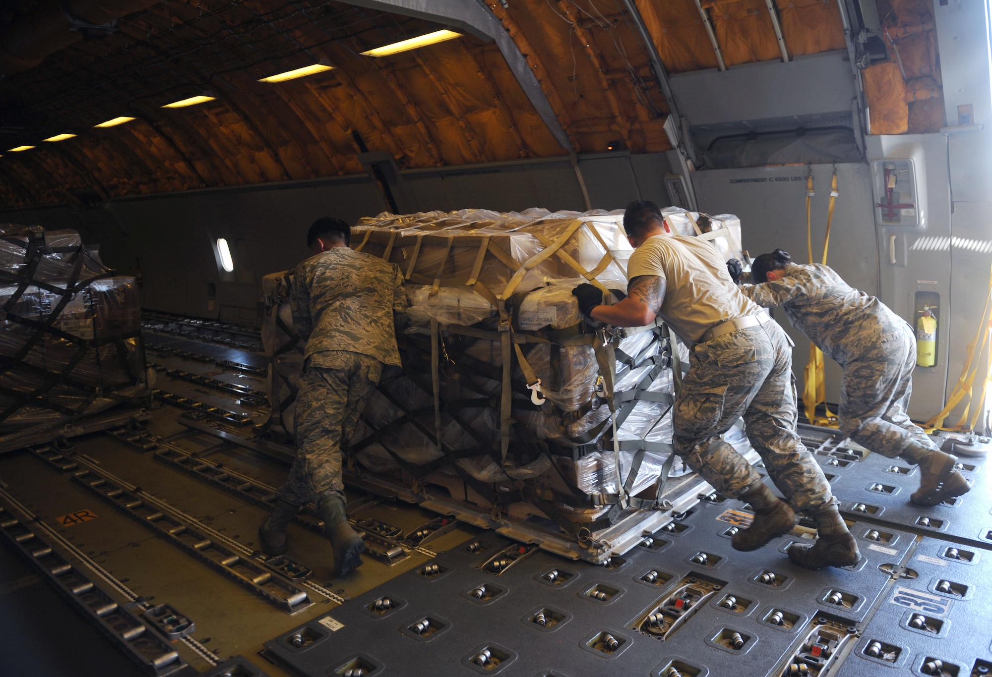 U.S. Air Force Airmen assigned to the 7th Logistics Readiness Squadron push a pallet of packed fortified dehydrated food into a KC-10 Extender at Dyess Air Force Base, Texas, Sept. 20, 2016. The shipment was the largest on record for Global Samaritan Resources for refuges in Iraq, equaling about 475,000 servings. (U.S. Air Force photo by Airman 1st Class Rebecca Van Syoc)