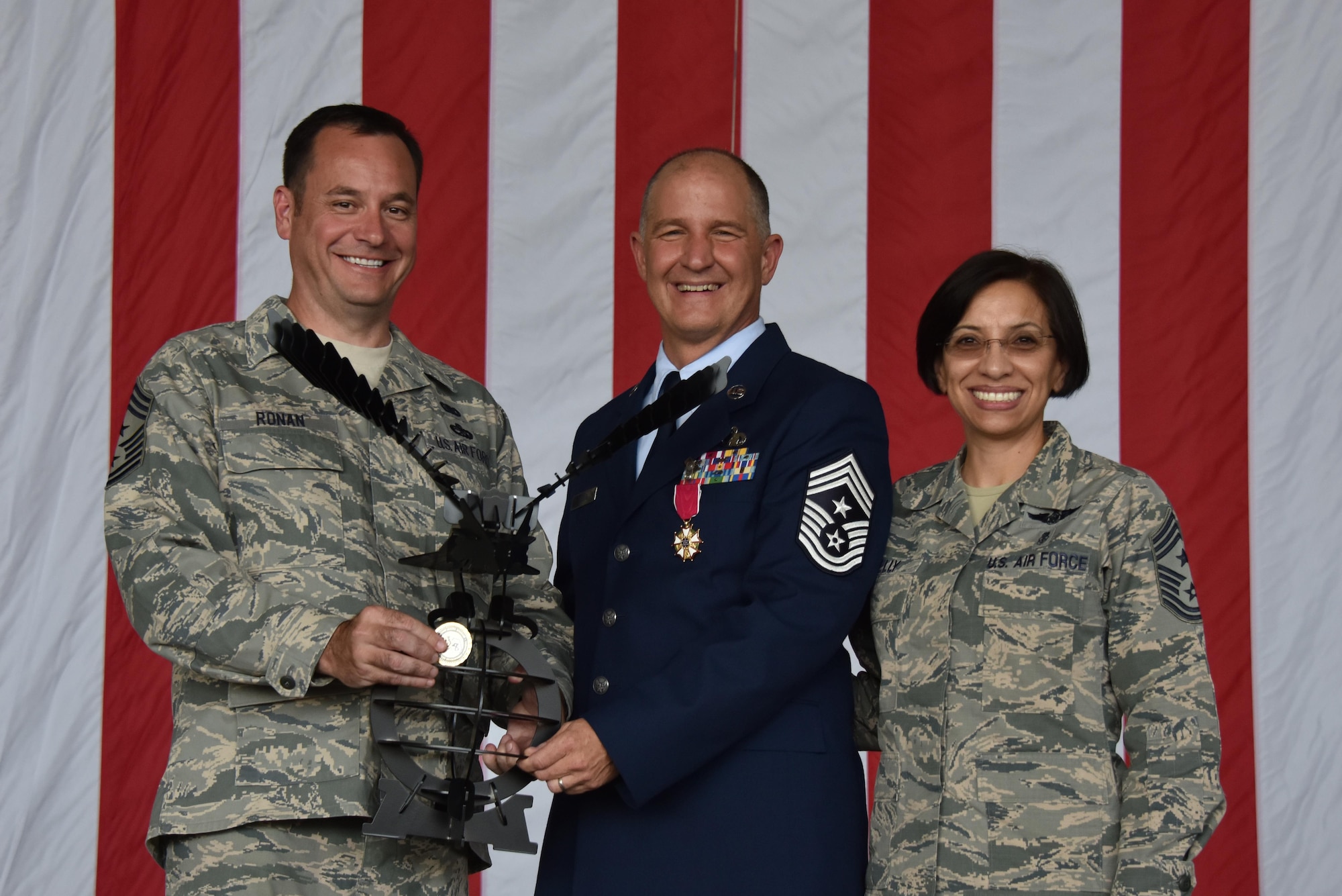 Chief Master Sgts. Clint Ronan and Erica Kelly, command chiefs of 22nd Air Force and Air Force Reserve Command respectively, present 911th Airlift Wing Command Chief Master Sgt. Brian Zator with a coin and special gift during his retirement ceremony at the Pittsburgh International Airport Air Reserve Station, September 10, 2016. Kelly and Ronan said that they had worked with Zator previously and considered him a brother. (U.S. Air Force photo by Staff Sgt. Marjorie A. Bowlden) 