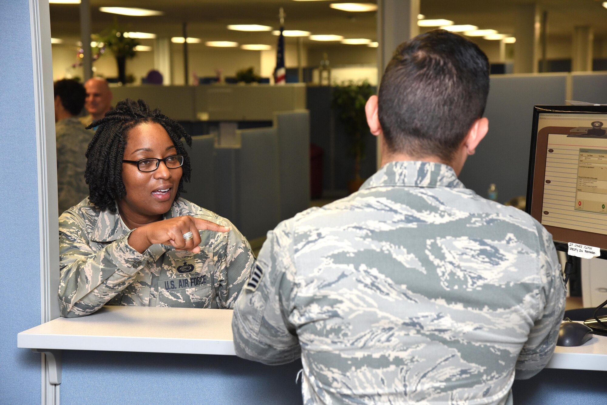 Master Sgt. Deborah McLean, 403rd Force Support Squadron noncommissioned officer in charge, assists a customer with signing in at the Sablich Center at Keesler Air Force Base, Mississippi, August 8, 2016. The reserve 403rd FSS co-located to the center, where the active-duty 81st FSS is located, so both squadrons can provide more effective service to the Total Air Force customer. (U.S. Air Force photo by Tech. Sgt. Ryan Labadens)