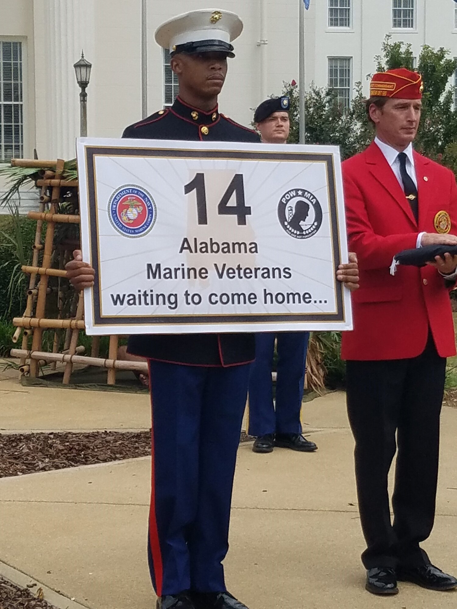 Cpl. Desmond Brooks, holds a sign indicating the number of Alabamians from the Marines who are still in MIA status. During the ceremony, Brooks Barrow, Marine Corps league, escorted the American flag to each service representative while their service song played. (U.S. Air Force photo/Eric Sharman)