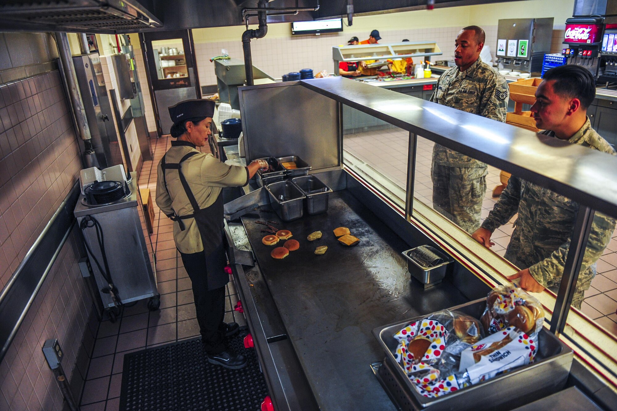 A member of the 8th Force Support Squadron dining facility kitchen staff cooks a hamburger and chicken at O’Malley’s Dining Facility at Kunsan Air Base, Republic of Korea, Sept. 22, 2016. O’Malley’s Dining Facility is scheduled to close for renovations from Sept. 26 to Nov. 6, 2016, which will allow multiple areas of the DFAC to be revamped, including serving lines, dining areas, floors and more. (U.S. Air Force photo by Senior Airman Colville McFee/Released)