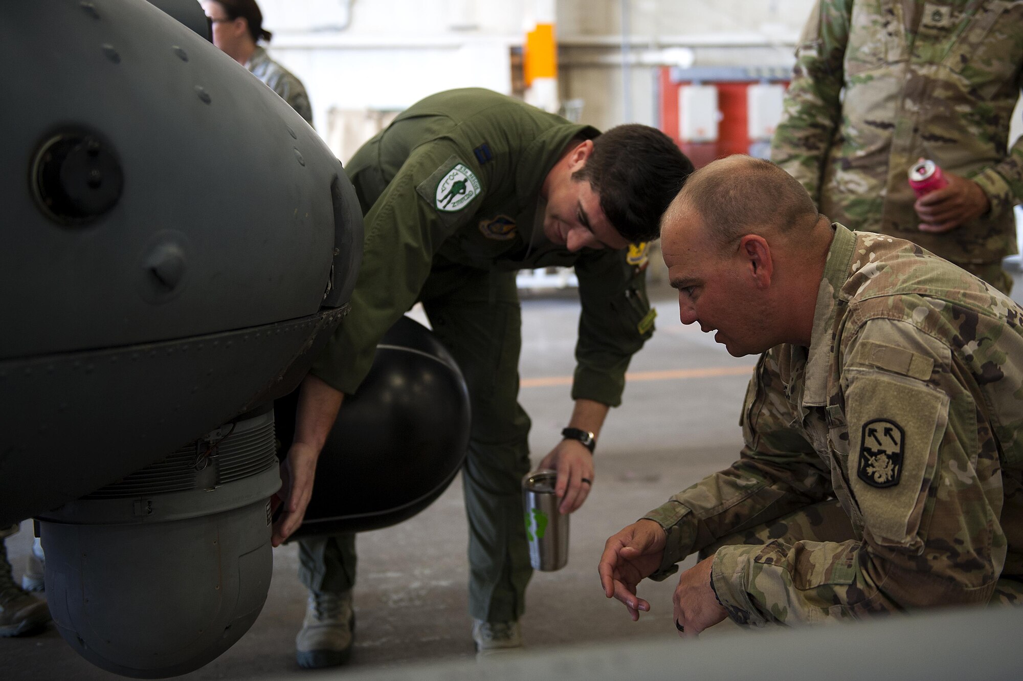 U.S. Air Force Capt. Evan Ross, 33rd Rescue Squadron pilot, shows the feature of the HH-60 Pave Hawk to students in the Joint Professional Military Education Okinawa Experience Sept. 21, 2016, at Kadena Air Base, Japan. After this experience, enlisted leaders will be able to take back a new perspective and relationships to their units.  (U.S. Air Force photo by Airman 1st Class Corey M. Pettis)