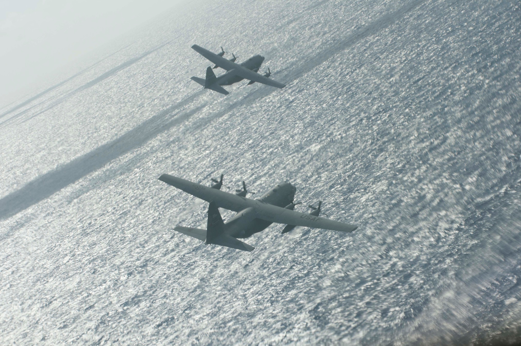 A flight of two C-130 Hercules aircraft from the Georgia Air National Guard's 165th Airlift Wing bank right while being escorted to a drop zone by fighter aircraft during Sentry Aloha at Joint Base Pearl Harbor-Hickam, Hawaii on Aug. 29 2016. Sentry Aloha exercises are held several times a year with the first one normally starting towards the beginning of the calendar year. (U.S. Air National Guard photo by Airman 1st Class Stan Pak/released)