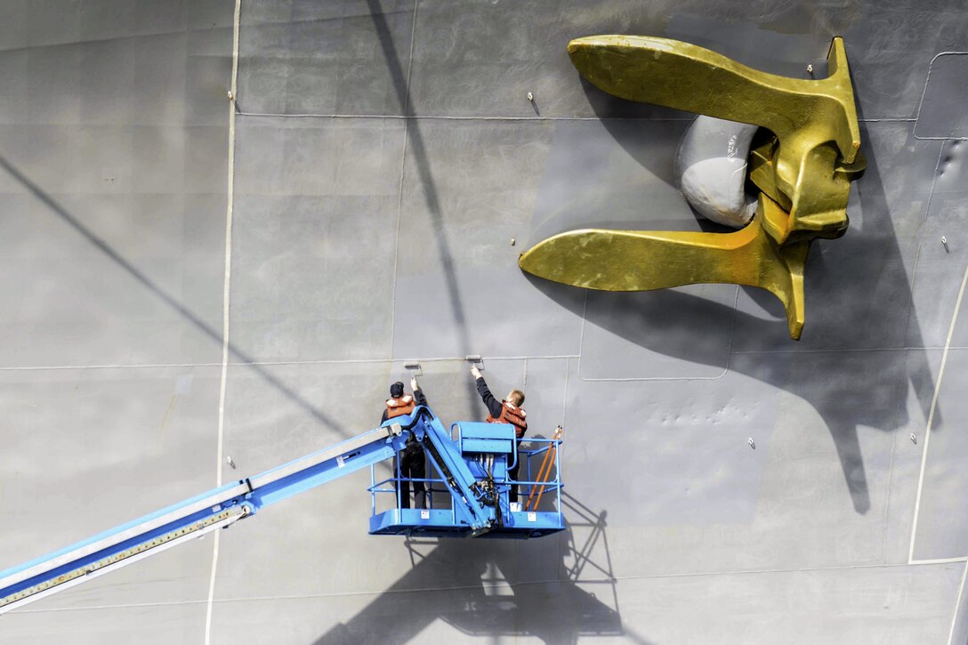 Navy Seaman Casey Dievendorf and Seaman Nathaniel Harris paint the hull of USS John C. Stennis in Bremerton, Wash., Sept. 21, 2016. The Stennis is conducting a routine maintenance following a deployment to the U.S. 7th and 3rd fleet areas of operation. Navy photo by Seaman Alexander P. Akre