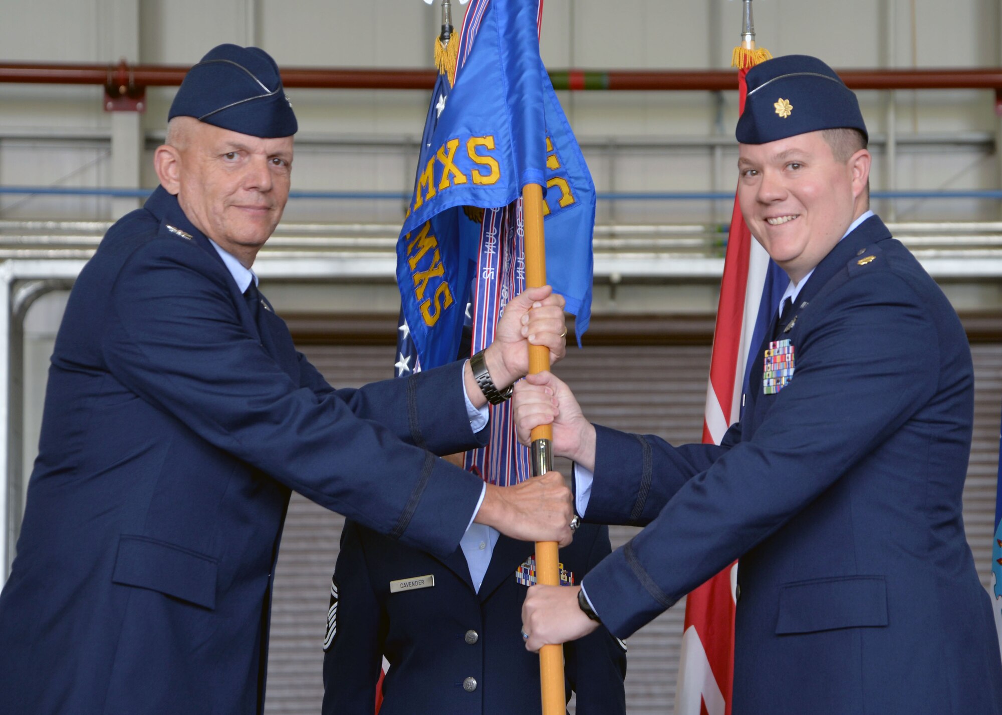 U.S. Air Force Col. Kelly Scott, left, 100th Maintenance Group commander, passes the guidon to U.S. Air Force Maj. Mitchell Foy, incoming 100th Aircraft Maintenance Squadron commander, Sept. 22, 2016, during a change of command ceremony on RAF Mildenhall, England. The ceremony is a time-honored tradition in which one officer relinquishes command and passes it to another. (U.S. Air Force photo by Karen Abeyasekere