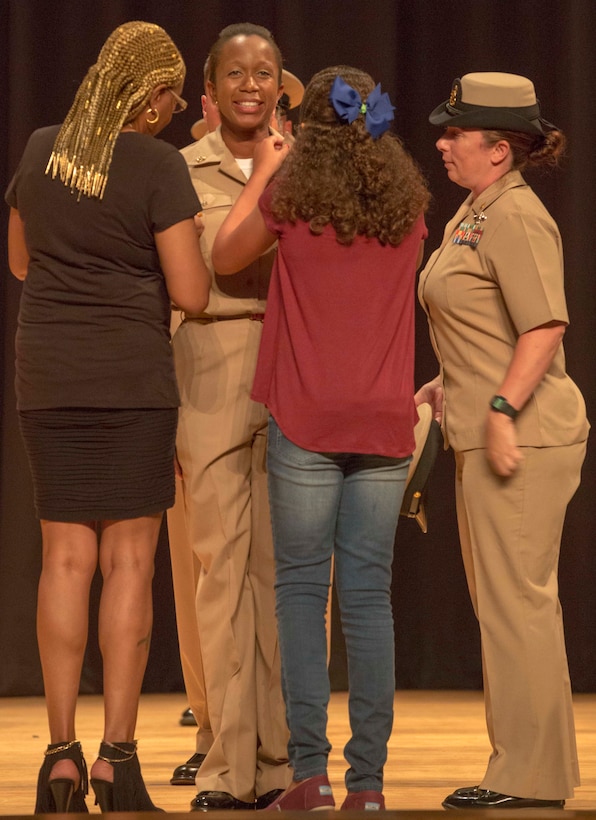 Chief Petty Officer Terry McCray-Matt, a newly Promoted Chief, gets pinned by her daughter Cyrah McCray-Matt and her mother Terry McCray at the base theater at Marine Corps Base Camp Lejeune, Sept. 16. The ceremony happened at the end of a six weeks transition period for Petty Officers 1st Class in to Chief Petty Officers where they are given first-hand knowledge on what it means to be a Chief in the Navy. (U.S. Marine Corps photo by Lance Cpl. Tavairus Hernandez /Released)