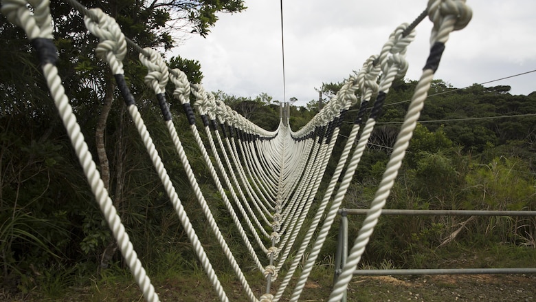 A three-strand obstacle sprawls over an open valley at the Jungle Warfare Training Center Sept. 20 on Okinawa, Japan. This obstacle is one of the 31 obstacles Marines must navigate during the culminating event of any JWTC course. JWTC is utilized for its harsh terrain and conditions to prepare Marines for operations in the Asia-Pacific Region and stretches over more than 17,000 acres.