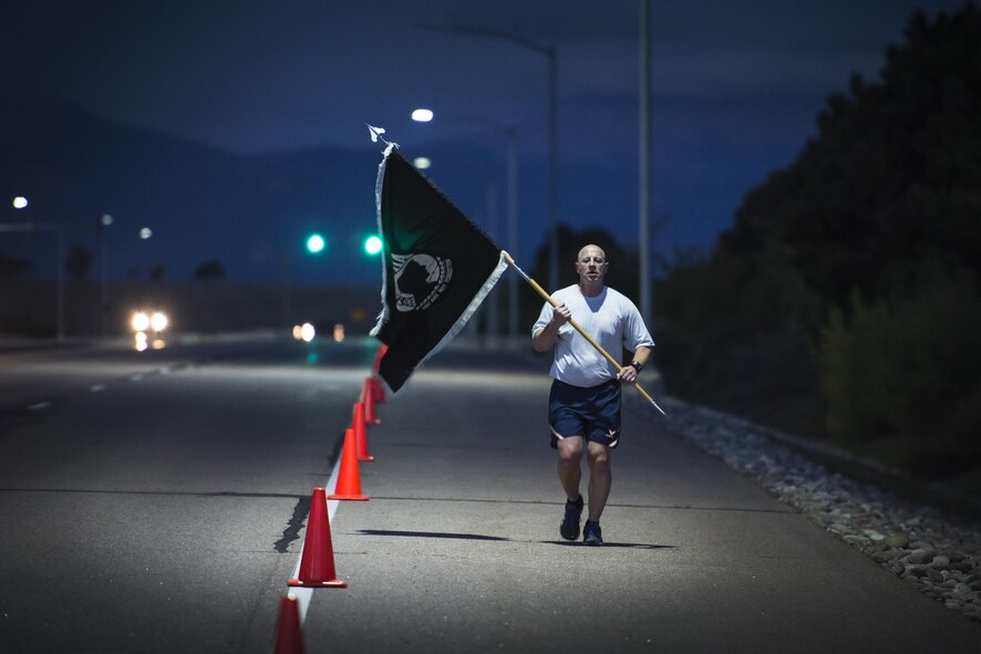 Peter Aronson, 19th Space Operations Squadron, runs alone with the prisoners of war and missing in action flag during the POW/MIA run at Schriever Air Force Base, Colorado, Thursday, Sept. 15, 2016. The flag was continuously carried for a full 24-hour period, even during the late night and early morning hours, symbolizing Schriever's dedication to honoring POW/MIA service members.(U.S. Air Force Photo/Dennis Rogers)