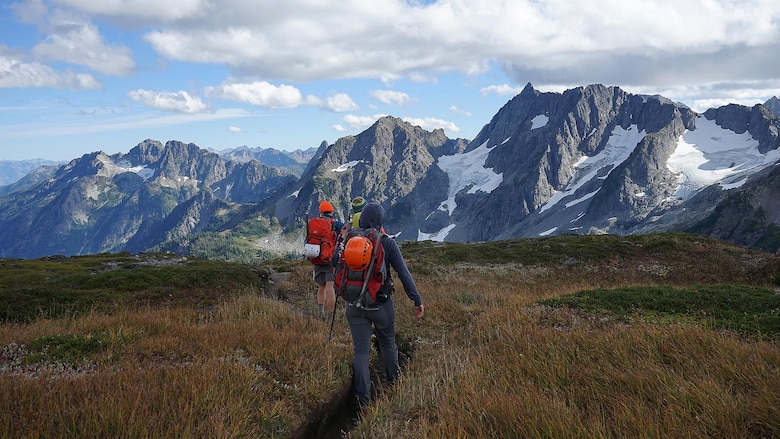 Melanie Stam (foreground), Capt. Nick Anthony (middle) and Ben Stilin (background) hike atop the Sahale Arm in North Cascades National Park, Washington, Sept. 10, 2016. After encountering an exhausted 77-year-old Norman Petty on a hike with his wife Barbara, photographer Colin Ayers, the pictured climbers and Catherine Mitchell (not pictured) led the couple visiting from Dunwoody, Georgia, to safety by transporting Norman Petty more than three miles using an impromptu support system. Anthony, from Norman, Oklahoma, is a U.S. Marine Corps recruiting management officer based in Seattle. Ayers, from Spokane, Washington, is a University of Washington chemical engineering student. Mitchell, from Seattle, is a content project manager at Microsoft. Stam, from Atlanta, is a Microsoft data analyst. Stilin, from Seattle, is a ski instructor at Husky Winter Sports.