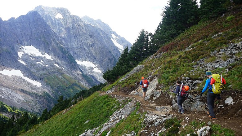 Ben Stilin (front), Melanie Stam (middle) and Capt. Nick Anthony (rear) hike down a switchback on their way to Cascade Pass in North Cascades National Park, Washington, Sept. 10, 2016. After encountering an exhausted 77-year-old Norman Petty on a hike with his wife Barbara, photographer Colin Ayers, the pictured climbers and Catherine Mitchell (not pictured) led the couple visiting from Dunwoody, Georgia, to safety by transporting Norman Petty more than three miles using an impromptu support system. Anthony, from Norman, Oklahoma, is a U.S. Marine Corps recruiting management officer based in Seattle. Ayers, from Spokane, Washington, is a University of Washington chemical engineering student. Mitchell, from Seattle, is a content project manager at Microsoft. Stam, from Atlanta, is a Microsoft data analyst. Stilin, from Seattle, is a ski instructor at Husky Winter Sports.