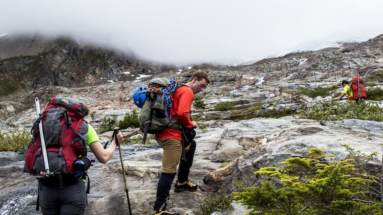 Melanie Stam (left), Colin Ayers (center) and Ben Stilin (left) ascend toward the Quien Sabe Glacier in North Cascades National Park, Washington, Sept. 10, 2016. After encountering an exhausted 77-year-old Norman Petty on a hike with his wife Barbara, photographer Capt. Nick Anthony, the pictured climbers and Catherine Mitchell (not pictured) led the couple visiting from Dunwoody, Georgia, to safety by transporting Norman Petty more than three miles using an impromptu support system. Anthony, from Norman, Oklahoma, is a U.S. Marine Corps recruiting management officer based in Seattle. Ayers, from Spokane, Washington, is a University of Washington chemical engineering student. Mitchell, from Seattle, is a content project manager at Microsoft. Stam, from Atlanta, is a Microsoft data analyst. Stilin, from Seattle, is a ski instructor at Husky Winter Sports.