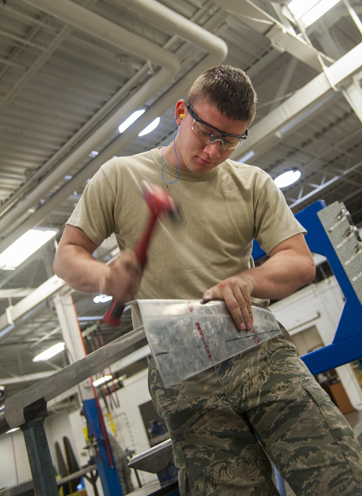Senior Airman Adam Hess, 5th Maintenance Squadron Aircraft structural maintenance journeyman, hand-forms a piece of metal at Minot Air Force Base, N.D., Sept. 20, 2016. Structural maintenance is responsible for repairing physical damage to B-52H Stratofortresses. (U.S. Air Force photo/Airman 1st Class Christian Sullivan)
