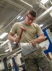 Senior Airman Adam Hess, 5th Maintenance Squadron Aircraft structural maintenance journeyman, hand-forms a piece of metal at Minot Air Force Base, N.D., Sept. 20, 2016. Structural maintenance is responsible for repairing physical damage to B-52H Stratofortresses. (U.S. Air Force photo/Airman 1st Class Christian Sullivan)