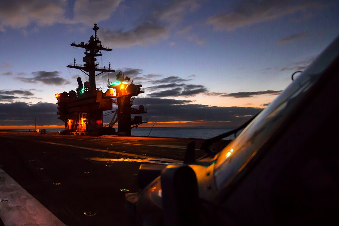 The sunset reflects off the windscreen of an MH-60S Sea Hawk helicopter on the flight deck of the aircraft carrier USS Carl Vinson in the Pacific Ocean, Sept. 14, 2016. Navy photo by Seaman Theo Shively