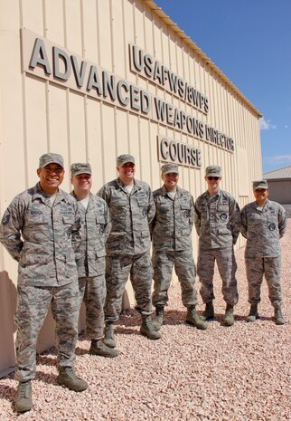 Master Sgt. Jorge Gonzalez, 8th Weapons Squadron Advanced Instructor Weapons Director Course superintendent, poses with his instructor cadre, (left to right) Technical Sgts. Philip Khandros, Corey Laird, Larry Cepeda, Timothy Moynihan and Jonie Escorpiso in front of the school building at Nellis Air Force Base, Nev., Aug. 31, 2016. The name on the school building, Advanced Weapons Director Course, reflects an earlier step in the AIWDC’s evolution to produce expert enlisted weapons director instructors. (U.S. Air Force Photo Susan Garcia) 