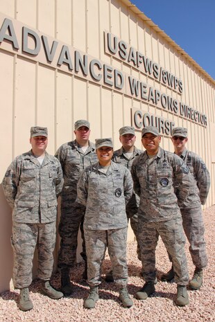 Master Sgt. Jorge Gonzalez, 8th Weapons Squadron Advanced Instructor Weapons Director Course superintendent, poses with his instructor cadre, (left to right) Technical Sgts. Philip Khandros, Corey Laird, Jonie Escorpiso, Larry Cepeda and Timothy Moynihan in front of the school building at Nellis Air Force Base, Nev., Aug. 31, 2016. The name on the school building, Advanced Weapons Director Course, reflects an earlier step in the AIWDC’s evolution to produce expert enlisted weapons director instructors. (U.S. Air Force Photo Susan Garcia) 