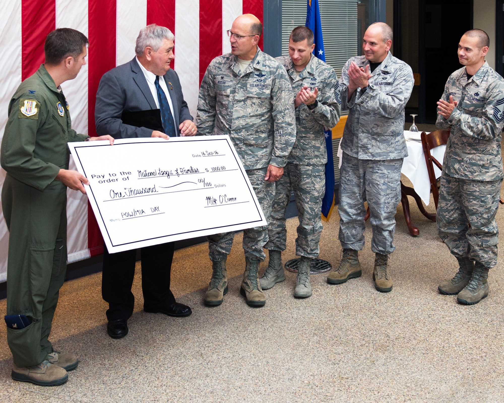 Former Prisoner of War Mike O’Connor is presented a check to the National League of Families on behalf of the Travis Air Force Base, Calif., leadership during the POW/MIA luncheon, Sept. 16, 2016.  O’Connor was held captive for more than five years after his aircraft crashed in South Vietnam in 1968, he was released in 1973 under the Paris Peace Accords. (U.S. Air Force photo by Louis Briscese)