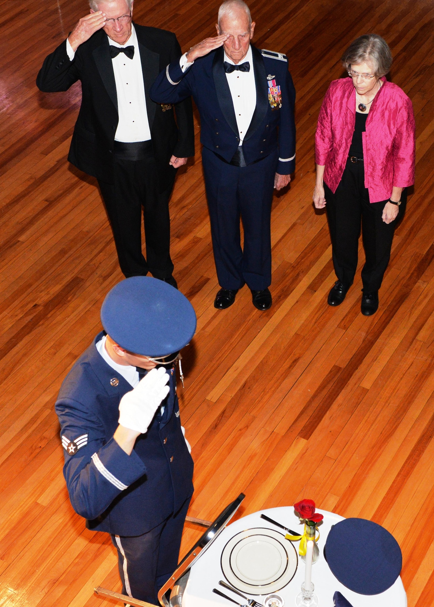 Retired Lt. Col. Gene Smith and retired Col. Carlyle “Smitty” Harris, both Vietnam F-105 pilots and former POWs, Jo Shumake, daughter of retired Col. Glynn Schumake, a B-17 World War II pilot and former POW, and a Columbus AFB Honor Guardsman salute the POW/MIA table during 69th Air Force Birthday Ball Sept. 17 at the Trotter Convention Center in Columbus, Mississippi. The Columbus AFB Honor Guard also received some special assistance during the ceremony as Smith, Harris and Shumake provided some of the symbolic memorializations at the POW/MIA table. (U.S. Air Force photo by Richard Johnson)