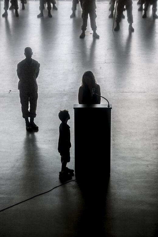 Aaron Grogan looks up at his mother Lynn, as she speaks at his father’s memorial service Sept. 18, 2016, at Naval Air Station Joint Reserve Base New Orleans, La. Maj. Jason Grogan and Maj. Erik A. Boyce were killed July 6, 2016, when the Bell 525 helicopter they were piloting crashed near Arlington, Texas. Grogan and Boyce were both assigned to Marine Light Attack Helicopter Squadron 773, Detachment A, at NAS JRB New Orleans at the time of their deaths. 