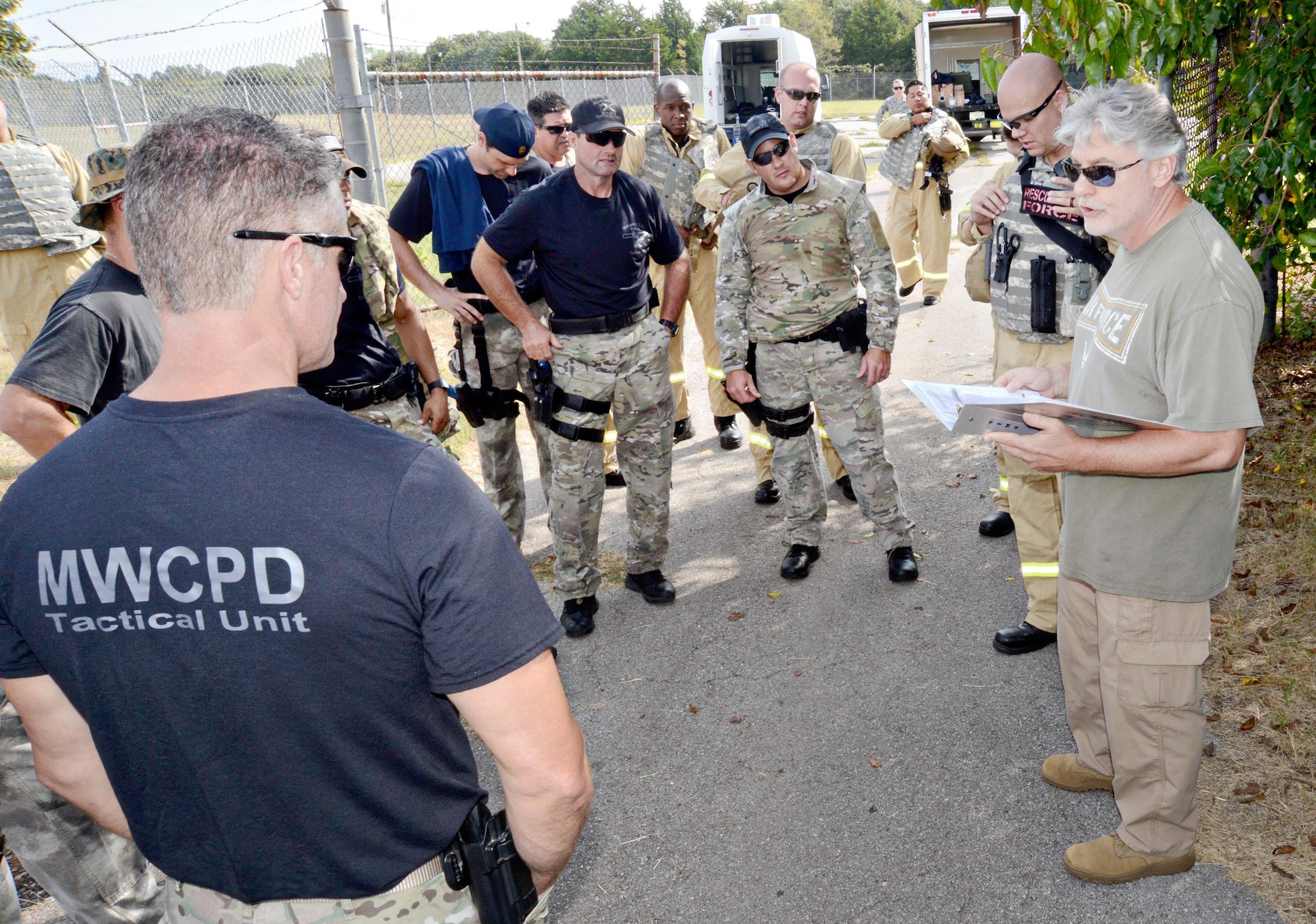 Members of the 72nd Security Forces Squadron, along with teams from the Midwest City SWAT, police and fire departments, get last minute instructions before their first active shooter training scenario on Sept. 15. (Air Force photo by Kelly White)