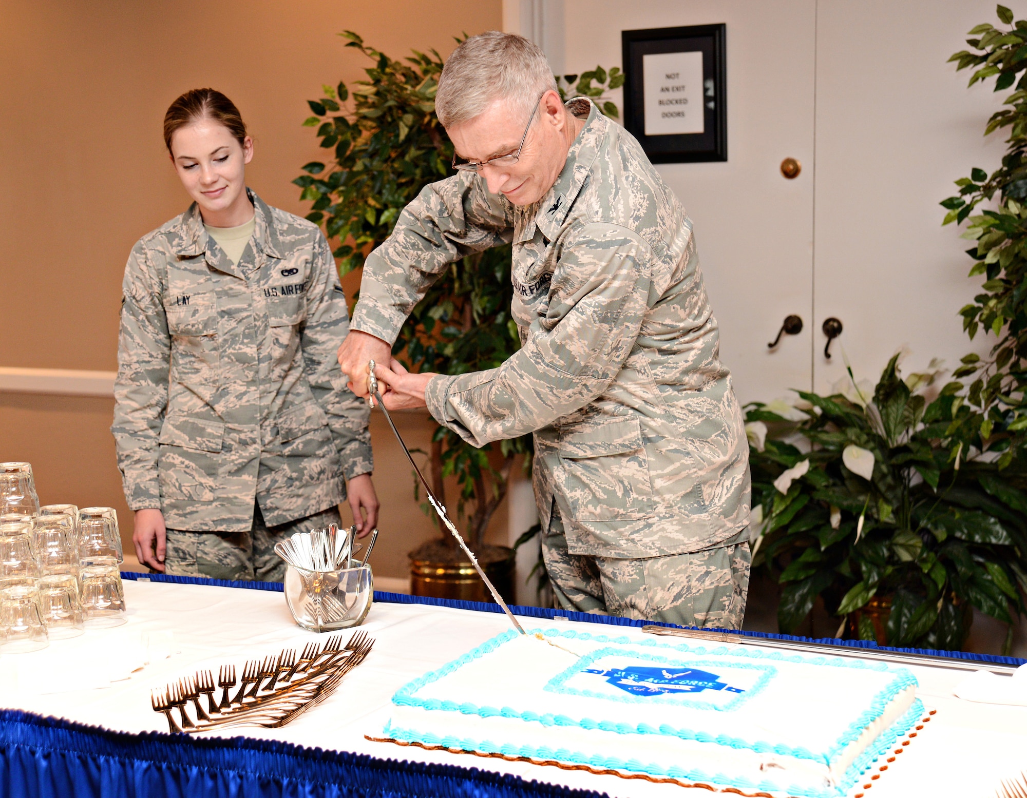 Retired Col. Steven Lamb, former 72nd Medical Group, makes the first slice of the cake at the Sept. 15 ceremony commemorating the Air Force’s 69th birthday as the oldest active duty member. Airman Allison Lay, with the 552nd Maintenance Squadron, was the youngest attending member and made the second slice. (Air Force photo by Kelly White)