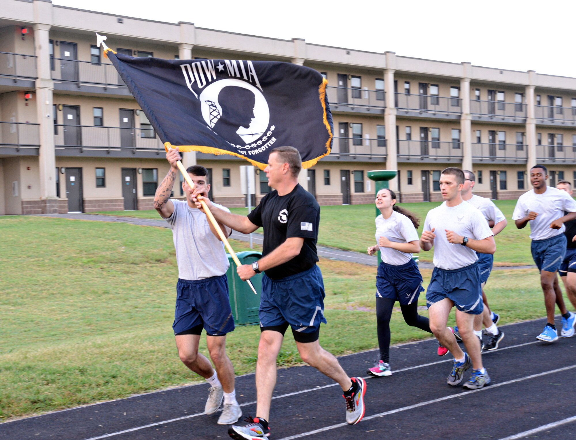 Chief Master Sgt. Roger Turnipseed, with the 552nd Aircraft Maintenance Squadron and also with the Tinker Chief’s Group, passes the POW/MIA flag to a member of the 72nd Force Support Squadron during the 24-hour Vigil Run as part of Tinker’s POW/MIA events. Members of Team Tinker took turns carrying the POW/MIA flag around the Tinker track from 7:30 a.m. Sept. 15 to 7:30 a.m. Sept. 16 when it was moved from the track to the POW/MIA Breakfast at the Tinker Club. The flag was then passed to the youngest Airman at the breakfast and posted at the front of the room during the ceremony. After the breakfast, the flag was handed off to participants of the POW/MIA Ruck March and carried for the entire 10K. Later that day, the flag was taken to the Del City American Legion and VFW Post 9969 for a POW/MIA Retreat Ceremony. At the retreat, it was announced that the flag had been moved by approximately 120 Airmen, civilians, contractors, and dependents for a total of 160.15 miles. (Air Force photo by Kelly White)