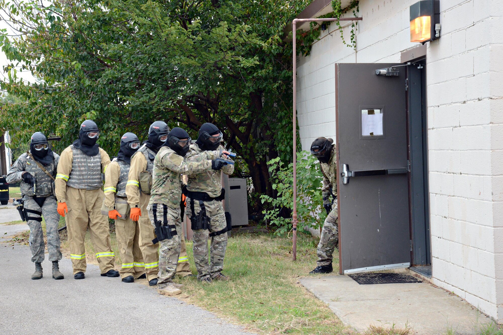 Members of the 72nd Security Forces Squadron, along with teams from the Midwest City SWAT, police and fire departments, prepare to enter a simulated active shooter scene during training. (Air Force photo by Kelly White)