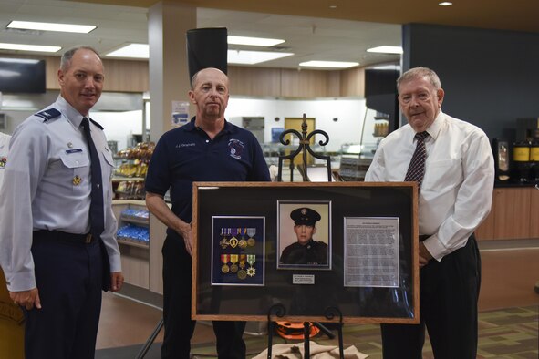 U.S. Air Force Col. Michael Downs, 17th Training Wing Commander, retired Chief Master Sgt. Ronald Graham and retired Master Sgt. Thomas Crowley, present a shadow box at the Cressman Dining Facility on Goodfellow Air Force Base, Sept. 22, 2016. The shadow box honored Sgt. Peter Cressman who was killed in action during a 6994th mission. (U.S. Air Force photo by Airman 1st Class Chase Sousa/Released)