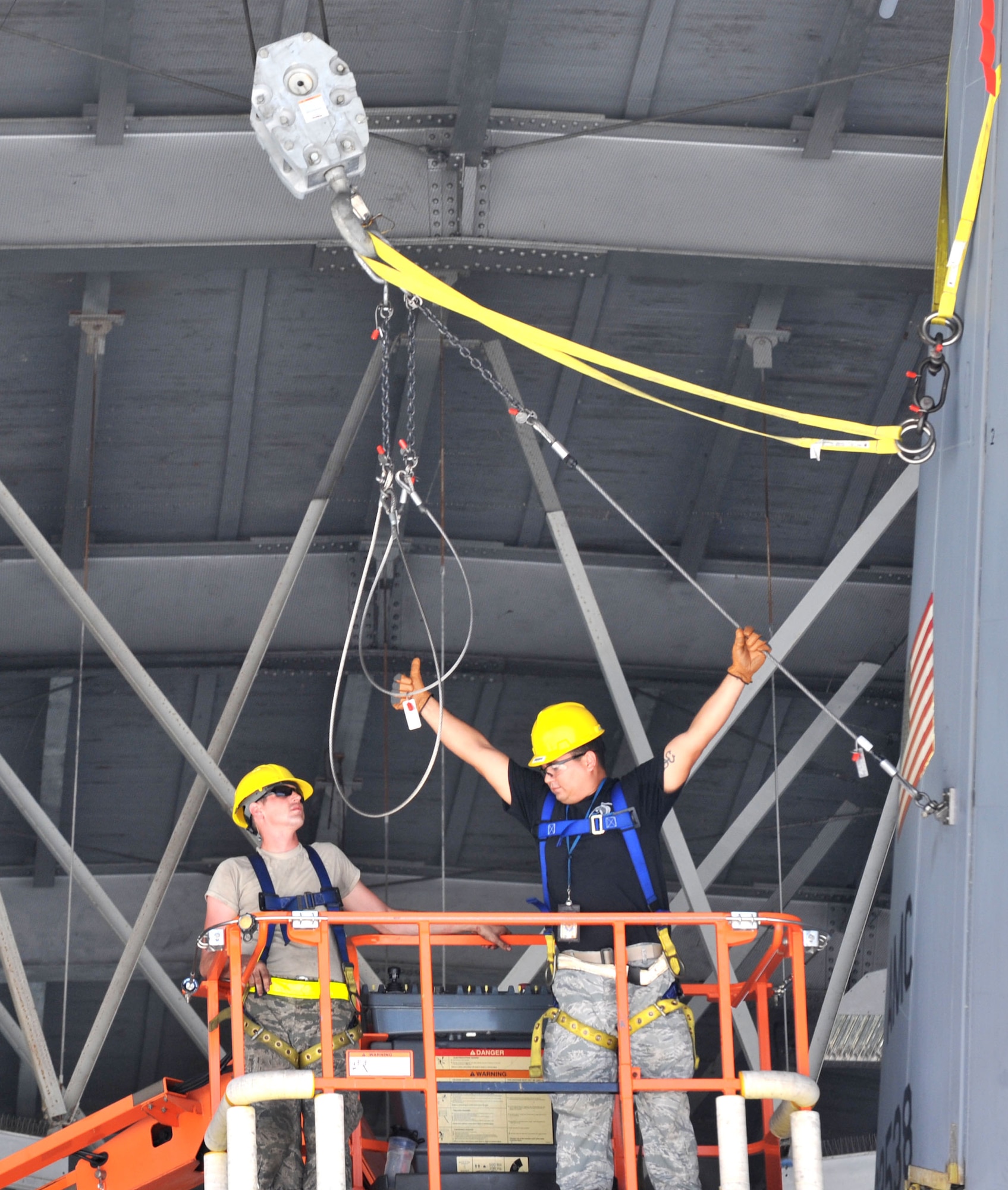 Senior Airman Michael Lewis, left, and Tech. Sgt. Martin De Jesus, right, aerospace maintainers assigned to the 6th Maintenance Squadron, guide a crane operator while fixing a KC- 135 Stratotanker Sept. 16, 2016 at MacDill Air Force Base, Fla. The crane had to be attached to straps on the fin to keep the fin from falling in order to make the repairs on the rudder. (U.S. Air Force photo by Airman 1st Class Rito Smith)  