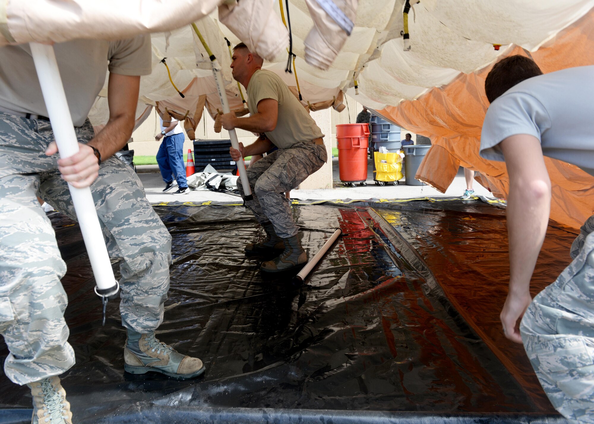 U.S. Air Force Staff Sgt. William Burnett Jr., 97 Medical Operations Squadron bioenvironmental engineer, instructs Airmen on Sept 21, 2016, Altus Air Force Base, Okla. This joint training prepared medical specialists from both Altus AFB and Sheppard AFB to help keep the medical centers clear of potential contaminate in the case of a chemical outbreak. (U.S. Air Force Photo by Airman Jackson N. Haddon/Released).